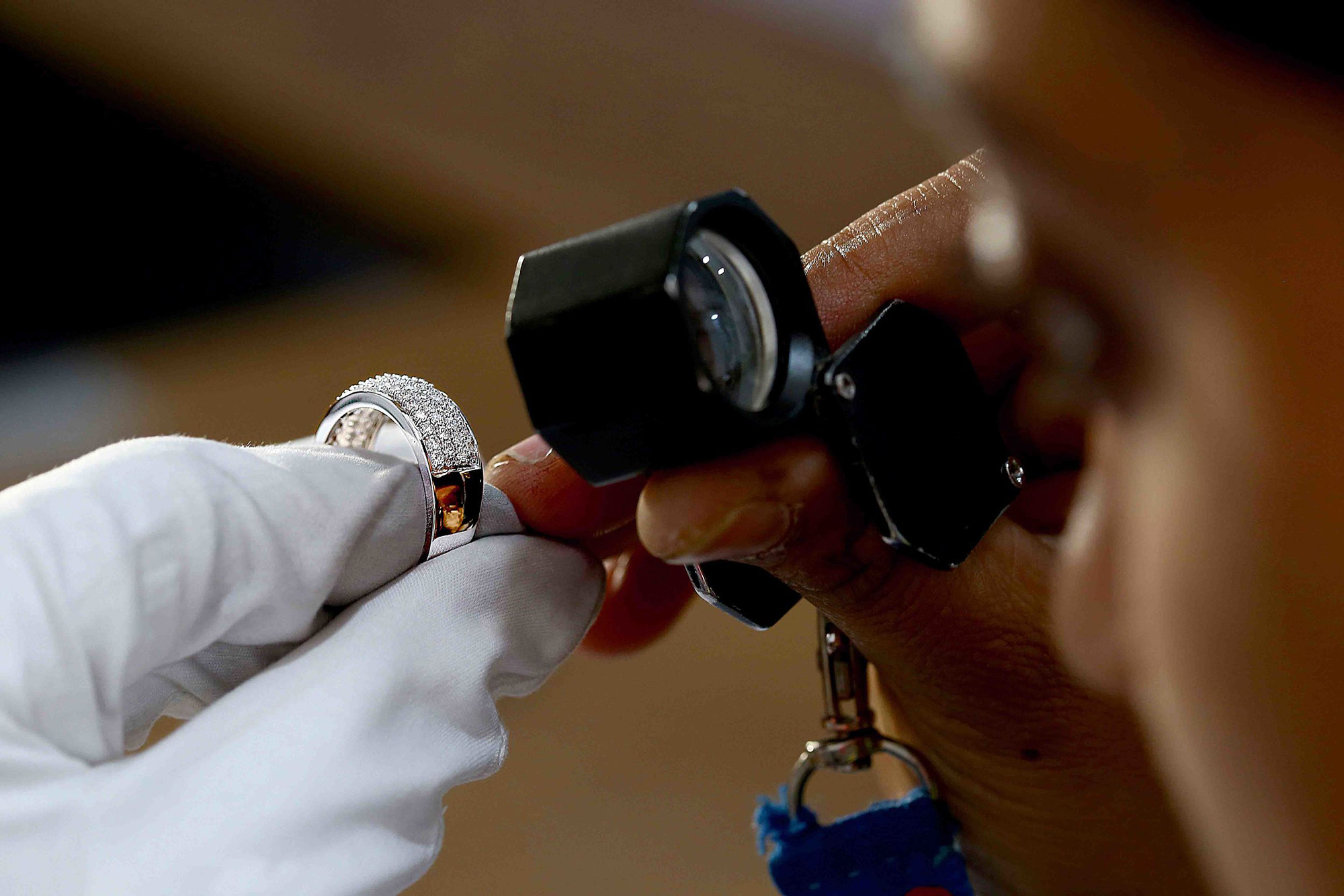 Man analyzes jewelry with a magnifying glass